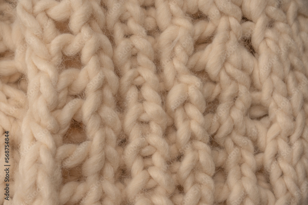 A fragment of beige knitted fabric, knitted from white sheep wool. A fragment of beige knitted fabric, knitted from white sheep wool.