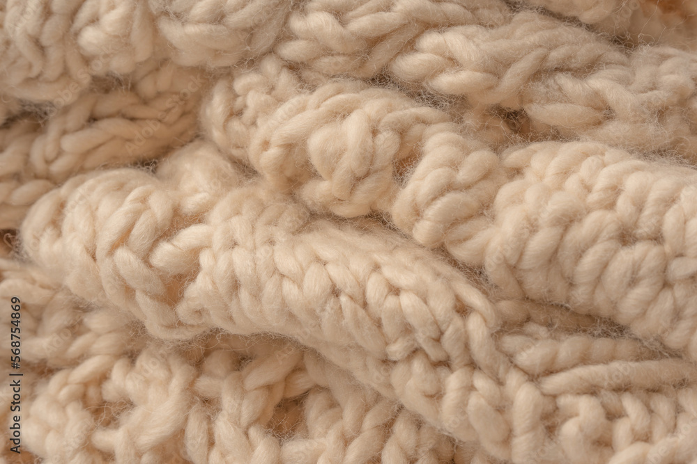 A fragment of beige knitted fabric, knitted from white sheep wool. A fragment of beige knitted fabric, knitted from white sheep wool.