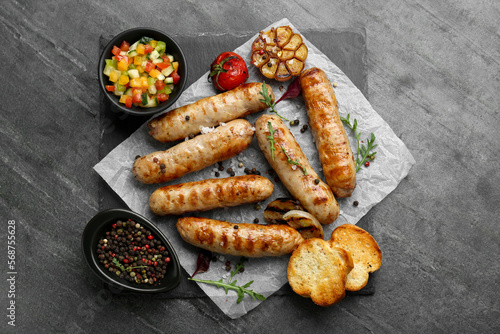 Tasty fresh grilled sausages with vegetables on grey table, flat lay