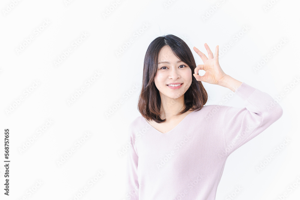 笑顔でグッドサインを示す若い女性 笑顔でグッドサインを示す若い女性