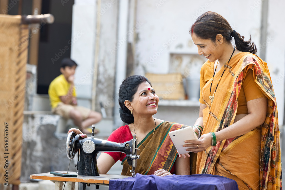 Indian woman using sewing machine at home. Indian woman using sewing machine at home.