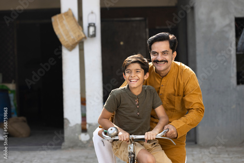Canvas Print Rural father and son riding bicycle together