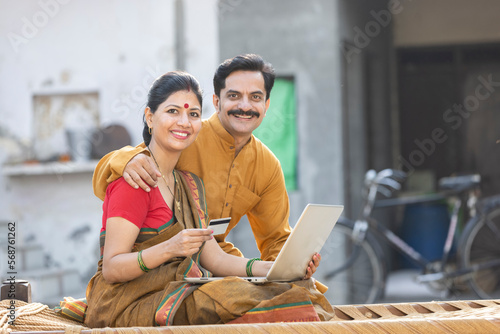 Photography Rural couple using laptop and credit card for online banking.