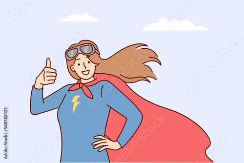 Woman superhero with picture of lightning on chest shows thumbs up on background of cloudy sky