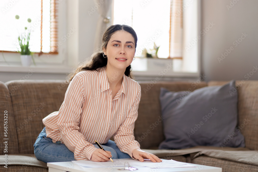 Purchase of real estate. Portrait of smiling woman fills documents. Concept of leasing, loan and mortgage Purchase of real estate. Portrait of smiling woman fills documents. Concept of leasing, loan and mortgage