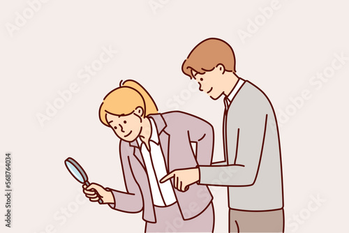 Man and woman working as detectives use magnifying glass during investigation to find evidence