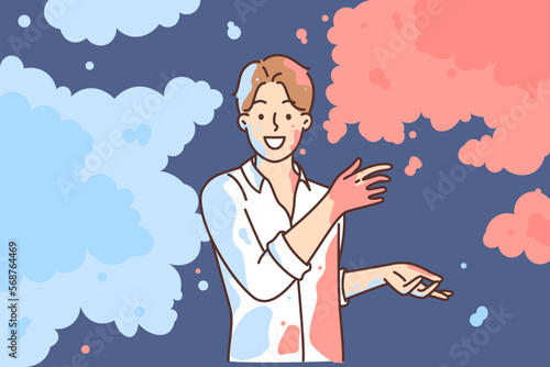 Man in white shirt scatters multi-colored powder on sides, wanting to share bright emotions
