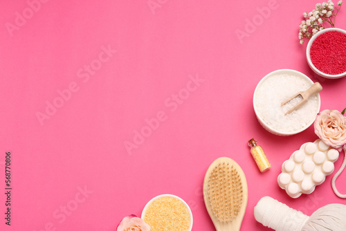 Sea salt and different spa products on pink background, flat lay. Space for text