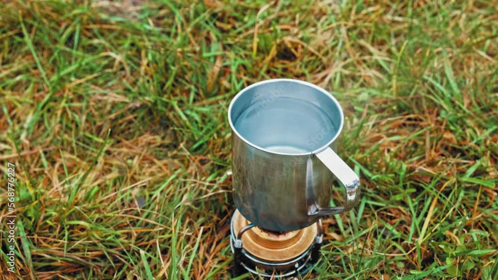 Water in Aluminum Metal Cup Heated on Hiking Camping Evaporation Alcohol Stove Portable Mini Spirit Burner Water in Aluminum Metal Cup Heated on Hiking Camping Evaporation Alcohol Stove Portable Mini Spirit Burner