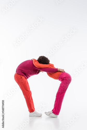 interracial couple in magenta color clothes showing o letter on white background.