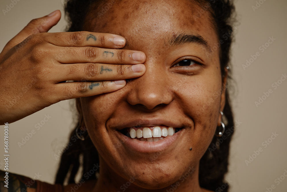 Fototapeta premium Close up ethnic young woman smiling candidly with one eye closed