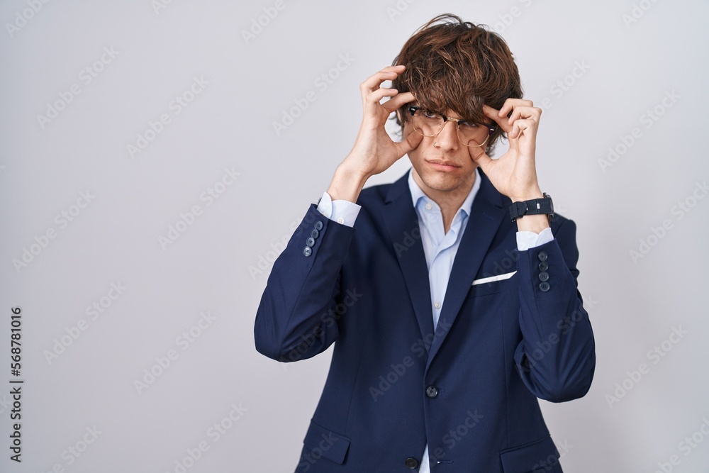 Hispanic business young man wearing glasses trying to open eyes with fingers, sleepy and tired for morning fatigue Hispanic business young man wearing glasses trying to open eyes with fingers, sleepy and tired for morning fatigue