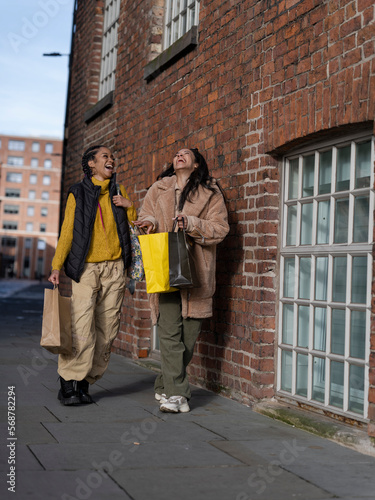 Two young women with shopping bags in urban setting