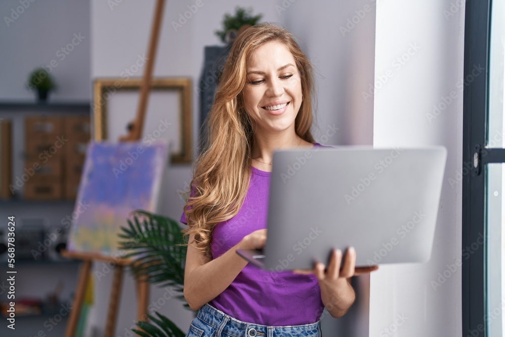 Young blonde woman artist smiling confident using laptop at art studio Young blonde woman artist smiling confident using laptop at art studio