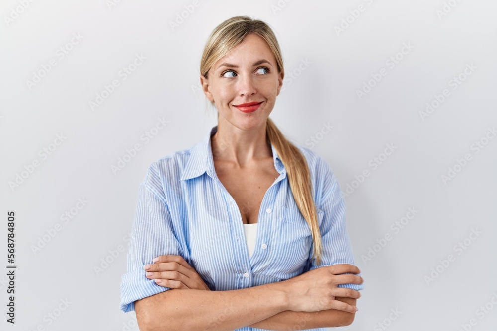 Beautiful blonde woman standing over white background smiling looking to the side and staring away thinking. Beautiful blonde woman standing over white background smiling looking to the side and staring away thinking.
