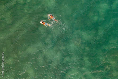 Indonesia, Lombok, Aerial view of men surfing in sea