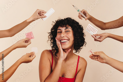 Women's reproductive health: Smiling woman in studio with hands holding contraceptive options for women