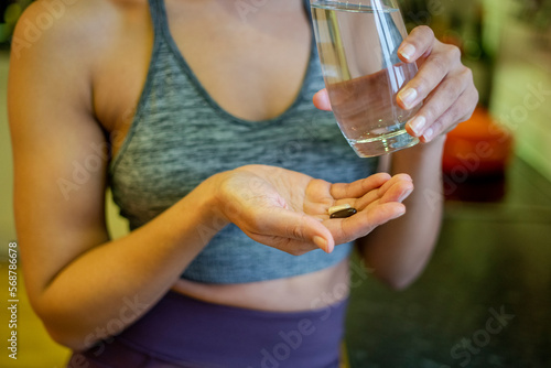 Young woman taking vitamins at home