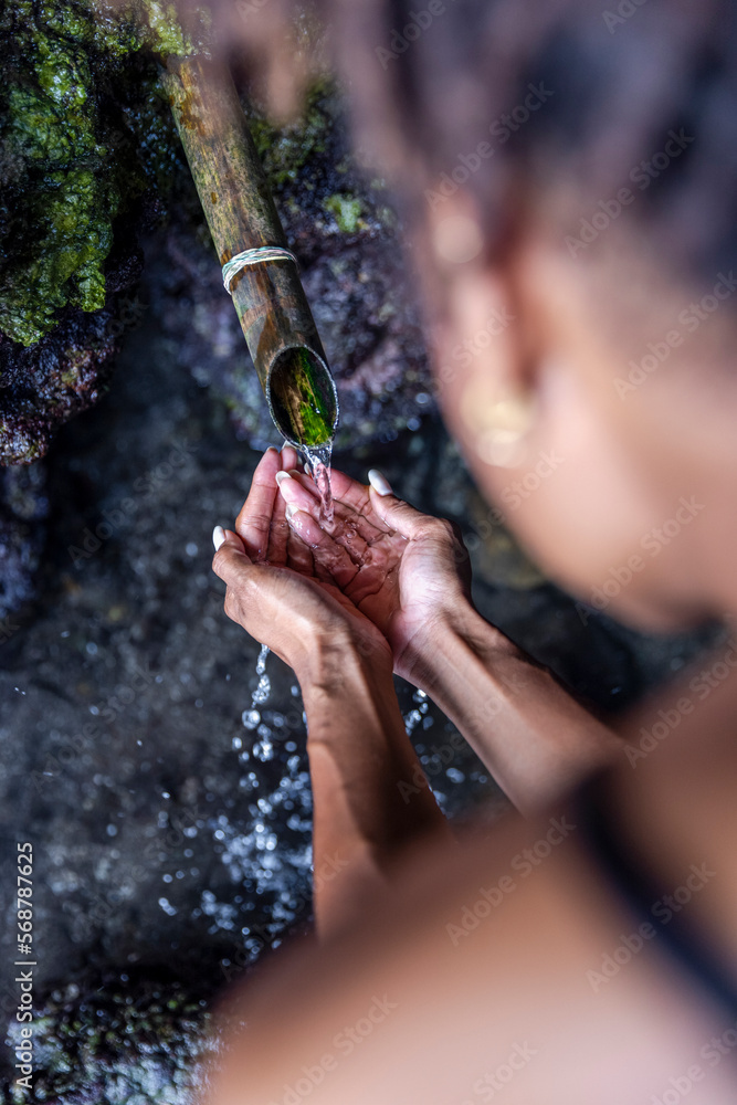 Woman taking water from drinking fountain