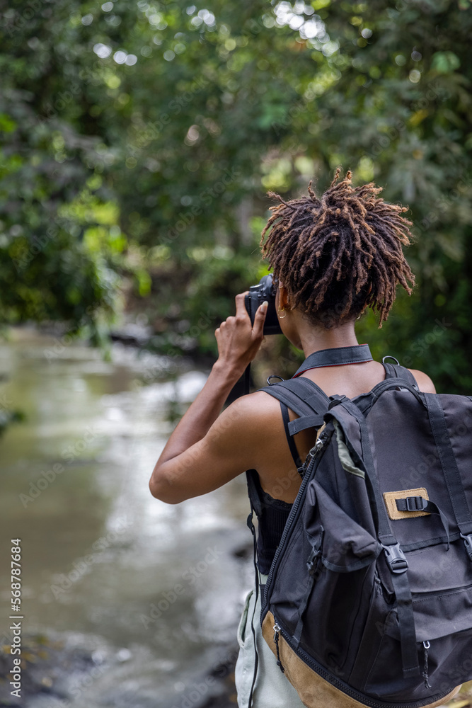 Indonesia, Bali, Female tourist photographing river during hike Indonesia, Bali, Female tourist photographing river during hike