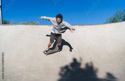 Male skateboarder riding fast on skateboard at skate park