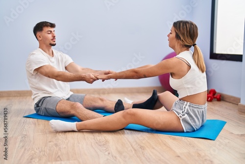 Young man and woman couple stretching at sport center