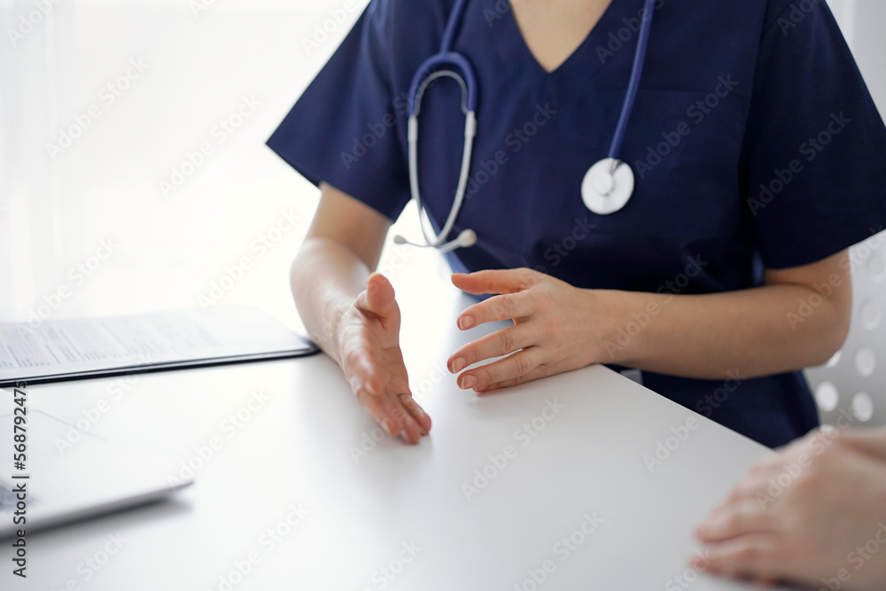 Doctor and patient discussing current health questions while sitting at the table in clinic, jast hands closeup. Medicine concept Doctor and patient discussing current health questions while sitting at the table in clinic, jast hands closeup. Medicine concept