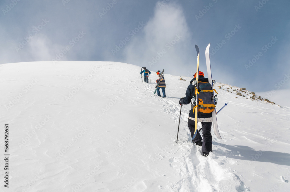 Backcountry climbers, ski climber, walking with skis and snowboard in the mountains. Ski tourism in the alpine landscape. Adventure winter sport