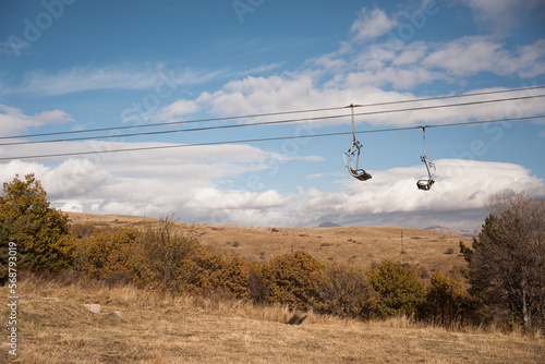 empty ropeway chairs of mountain ski resort in autumn photo