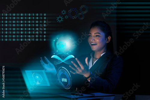 Businesswoman working on laptop computer with icons on virtual screen