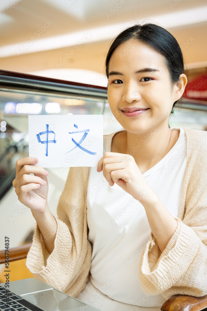 Smiling woman showing Mandarin Chinese vocab flash card, concept of foreign language learning Smiling woman showing Mandarin Chinese vocab flash card, concept of foreign language learning