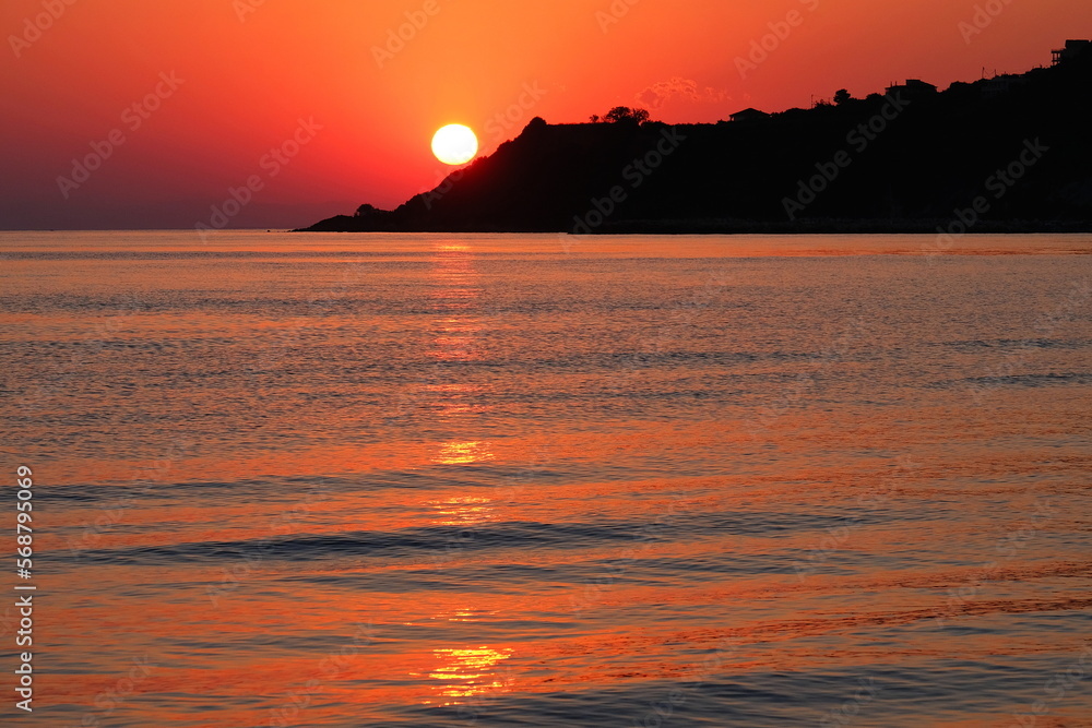 Naklejka premium Peaceful sunset with red sky, sea and mountains