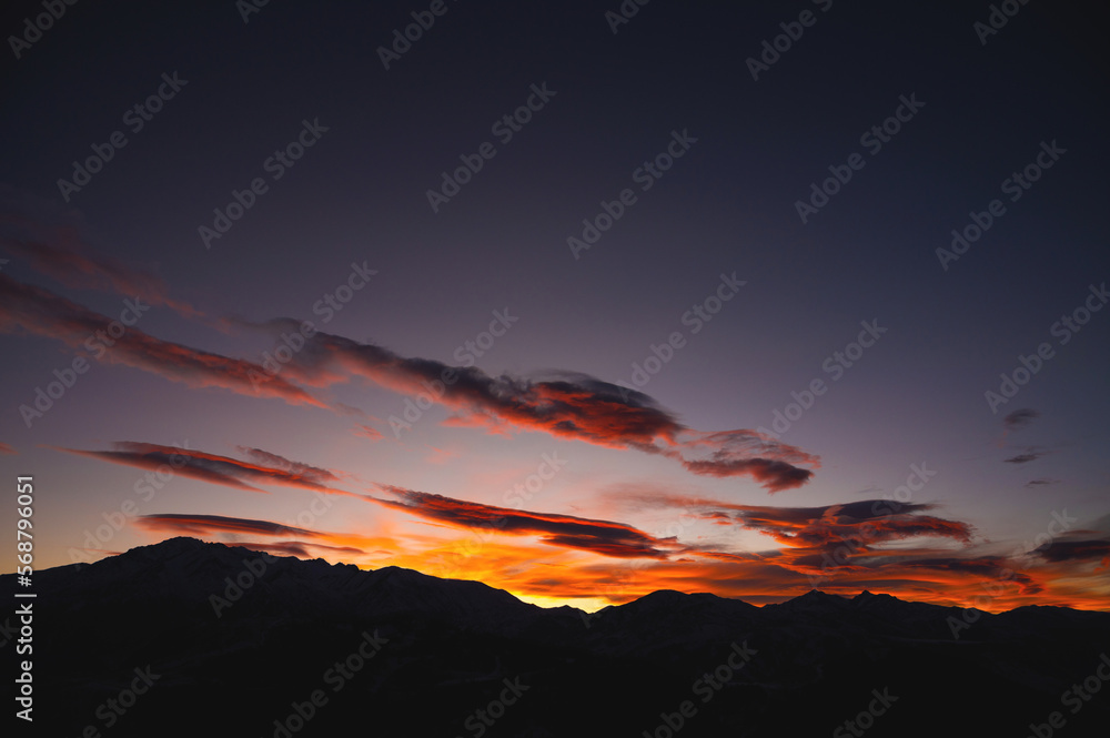 dusk, almost night. sunset sky in the last rays of the sun, fluffy clouds and the silhouette of mountains. picturesque