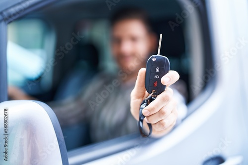 Young caucasian man smiling confident holding key of new car at street © Krakenimages.com