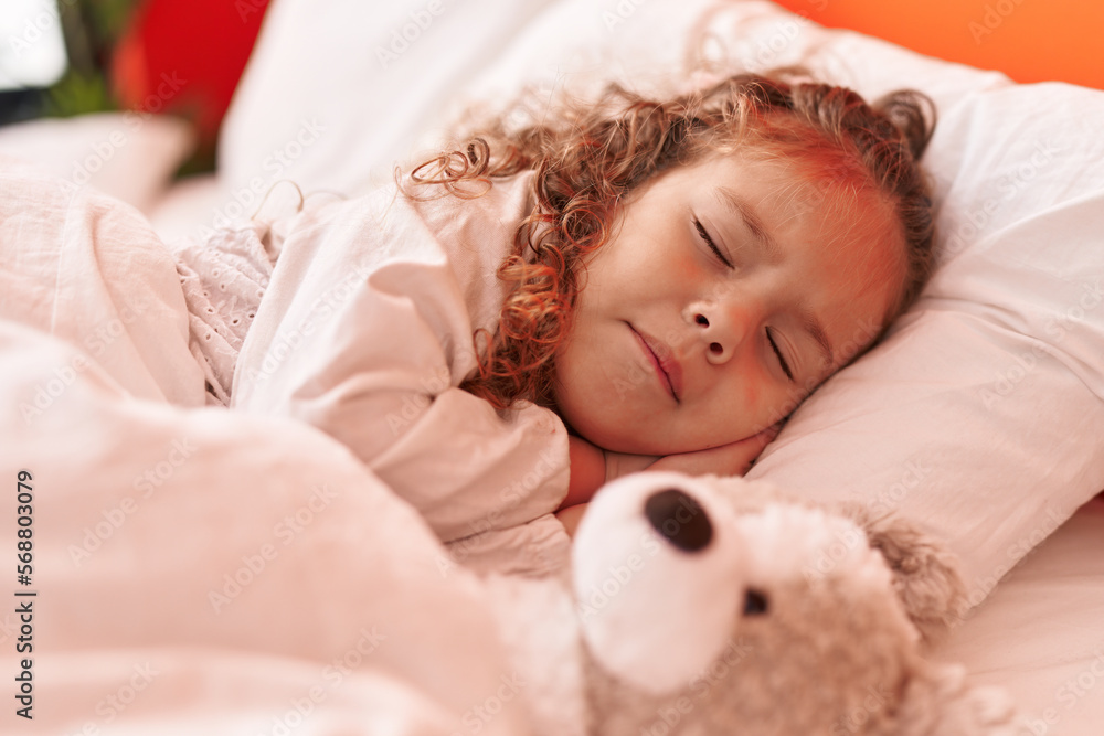 Adorable blonde toddler lying on bed sleeping with teddy bear at bedroom Adorable blonde toddler lying on bed sleeping with teddy bear at bedroom