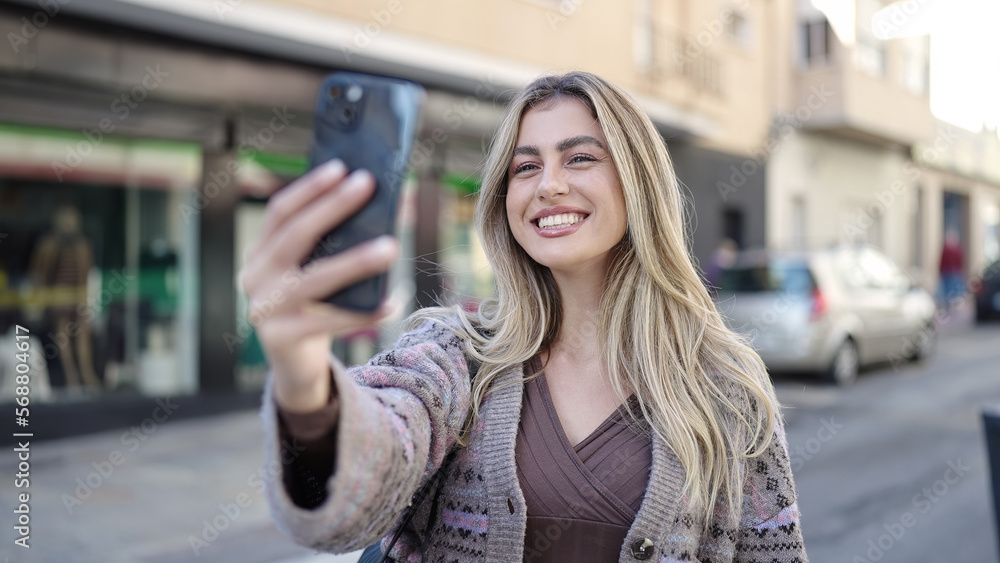 Young blonde woman smiling confident making selfie by the smartphone at street Young blonde woman smiling confident making selfie by the smartphone at street