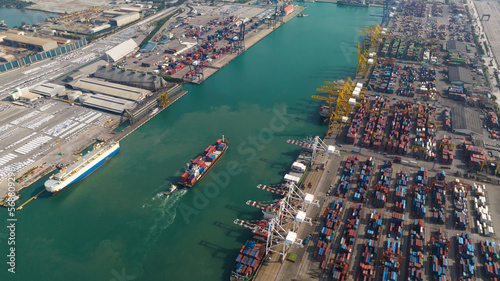 container ship and commercial port load and unloading cargo from container ship by crane to trailers transported aerial view © SHUTTER DIN