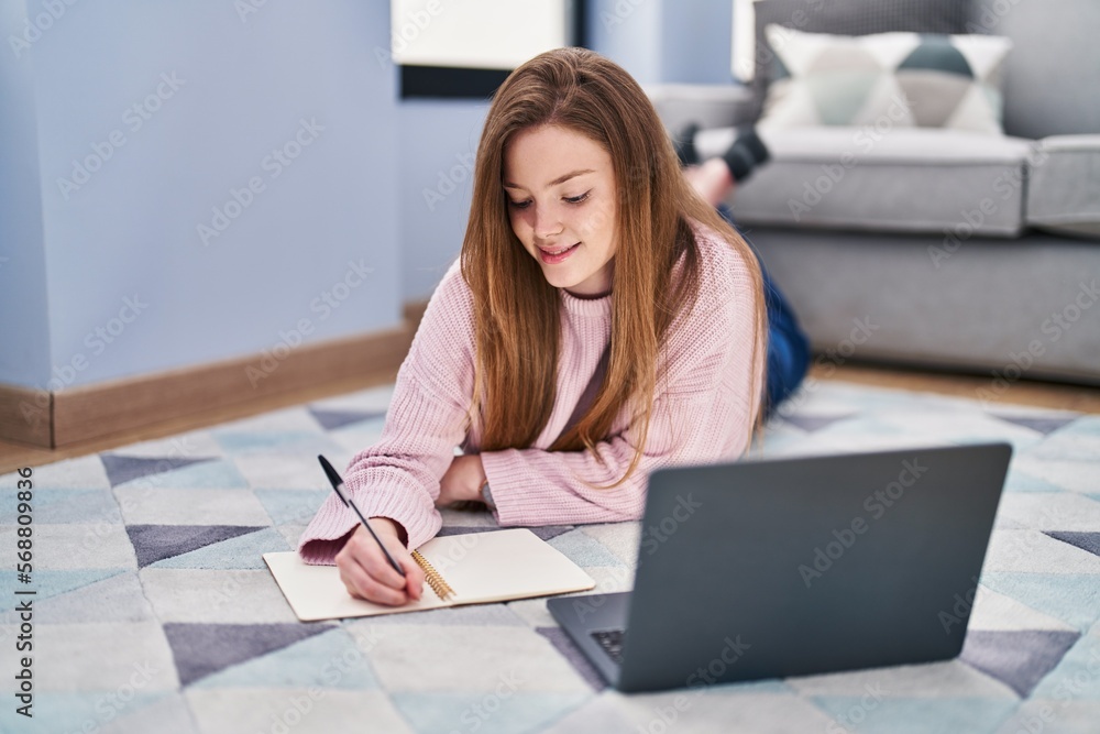 Young caucasian woman lying on floor studying at home Young caucasian woman lying on floor studying at home