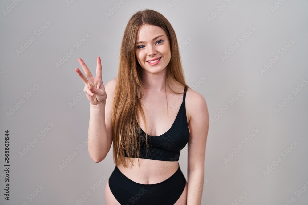 Young caucasian woman wearing lingerie showing and pointing up with fingers number three while smiling confident and happy. Young caucasian woman wearing lingerie showing and pointing up with fingers number three while smiling confident and happy.