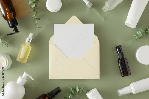 Organic cosmetic concept. Flat lay photo of cosmetic bottles, cream jars, dropper bottles, eucalyptus leaves on pastel green background and envelope with letter in the middle. Skincare products idea.