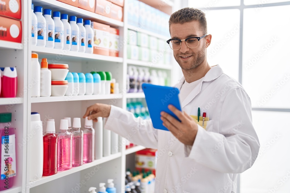 Young caucasian man pharmacist using touchpad working at pharmacy Young caucasian man pharmacist using touchpad working at pharmacy