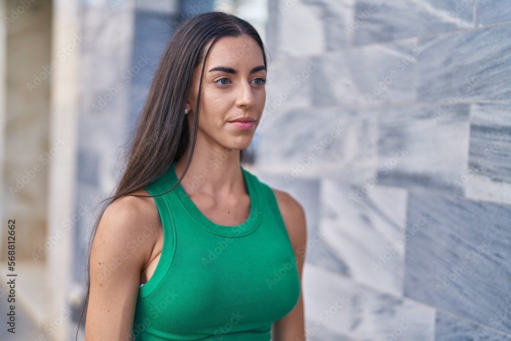 Young beautiful hispanic woman looking to the side with serious expression at street Young beautiful hispanic woman looking to the side with serious expression at street
