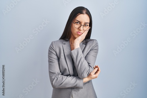 Hispanic business woman wearing glasses thinking looking tired and bored with depression problems with crossed arms.