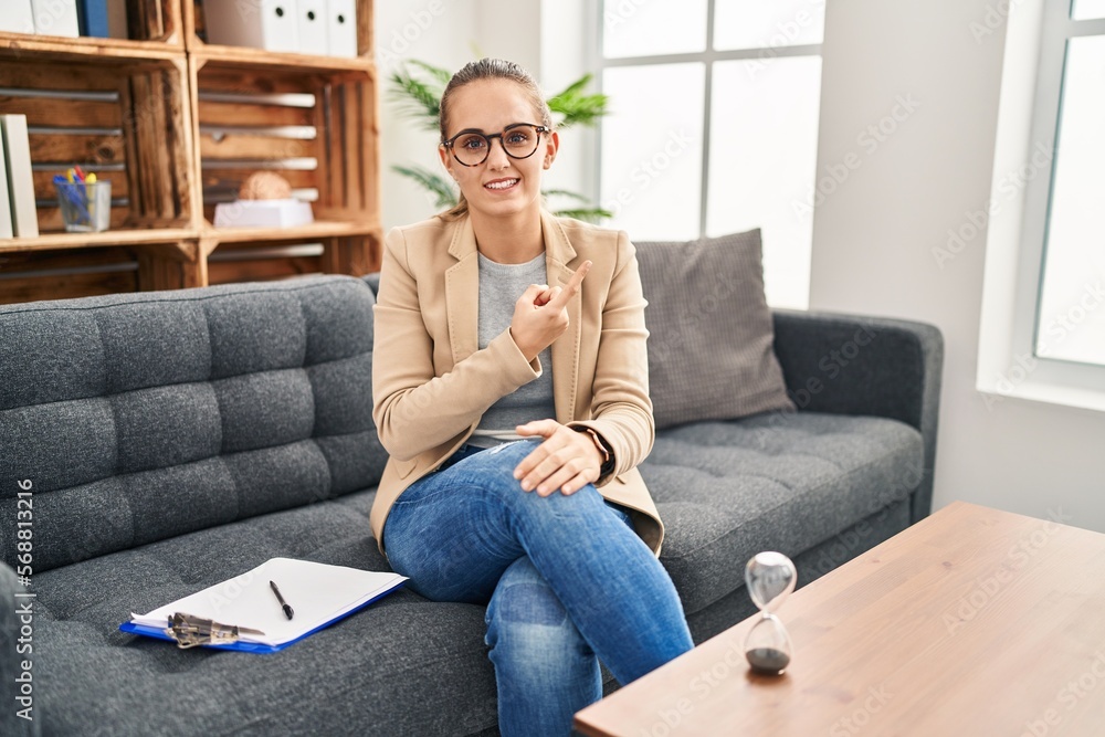 Young woman working at consultation office pointing aside worried and nervous with forefinger, concerned and surprised expression Young woman working at consultation office pointing aside worried and nervous with forefinger, concerned and surprised expression