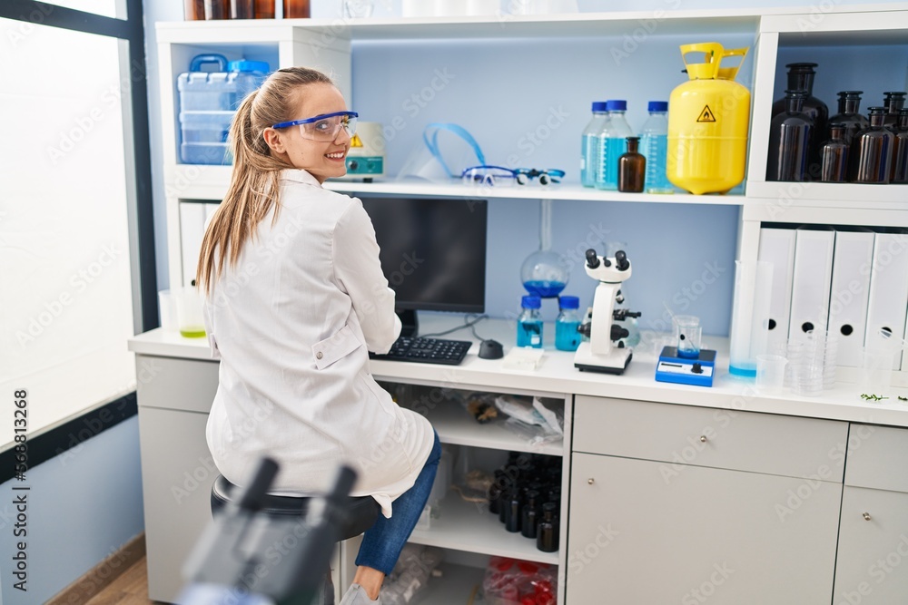 Young blonde woman wearing scientist uniform using computer working at laboratory Young blonde woman wearing scientist uniform using computer working at laboratory