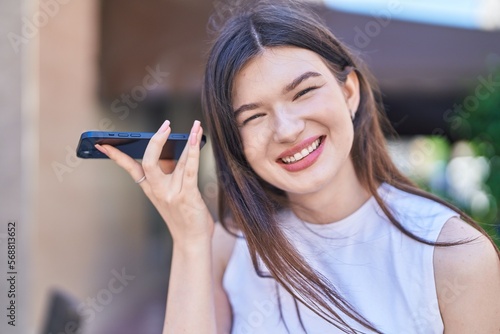Young caucasian woman smiling confident listening audio message by the smartphone at street