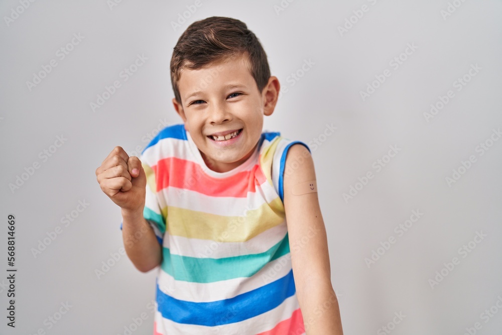 Young caucasian kid getting vaccine showing arm with band aid screaming proud, celebrating victory and success very excited with raised arm Young caucasian kid getting vaccine showing arm with band aid screaming proud, celebrating victory and success very excited with raised arm