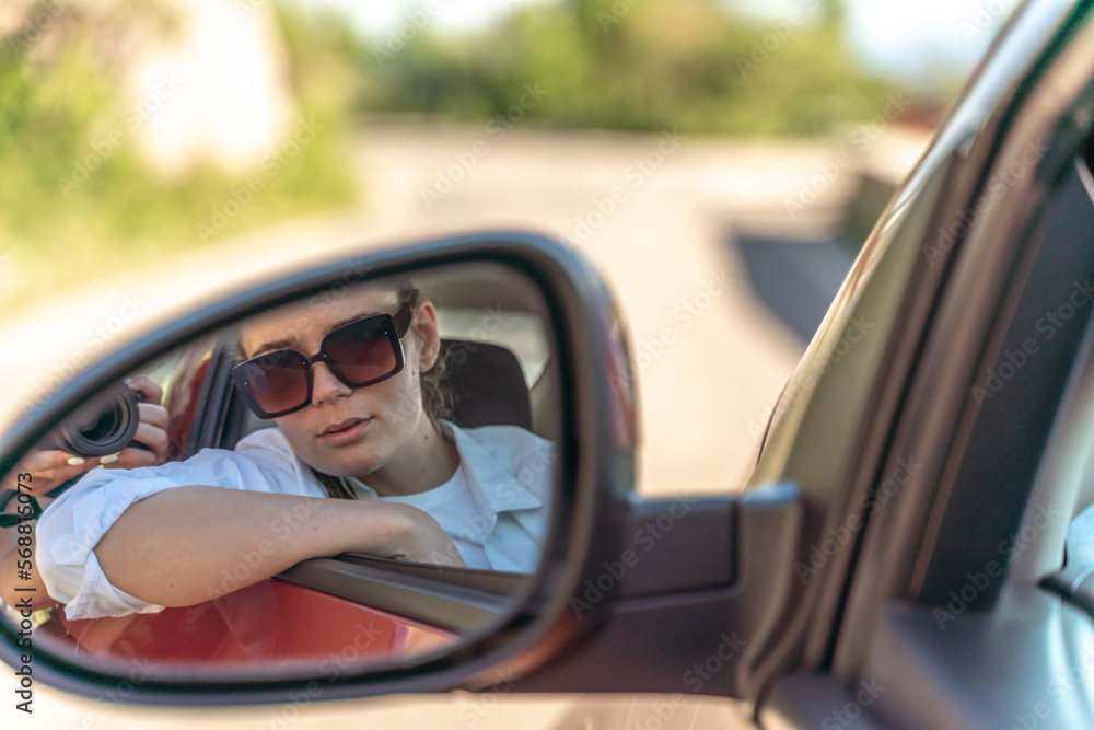 Woman car mirror. Portrait of a beautiful woman in a new car looking in the rearview mirror