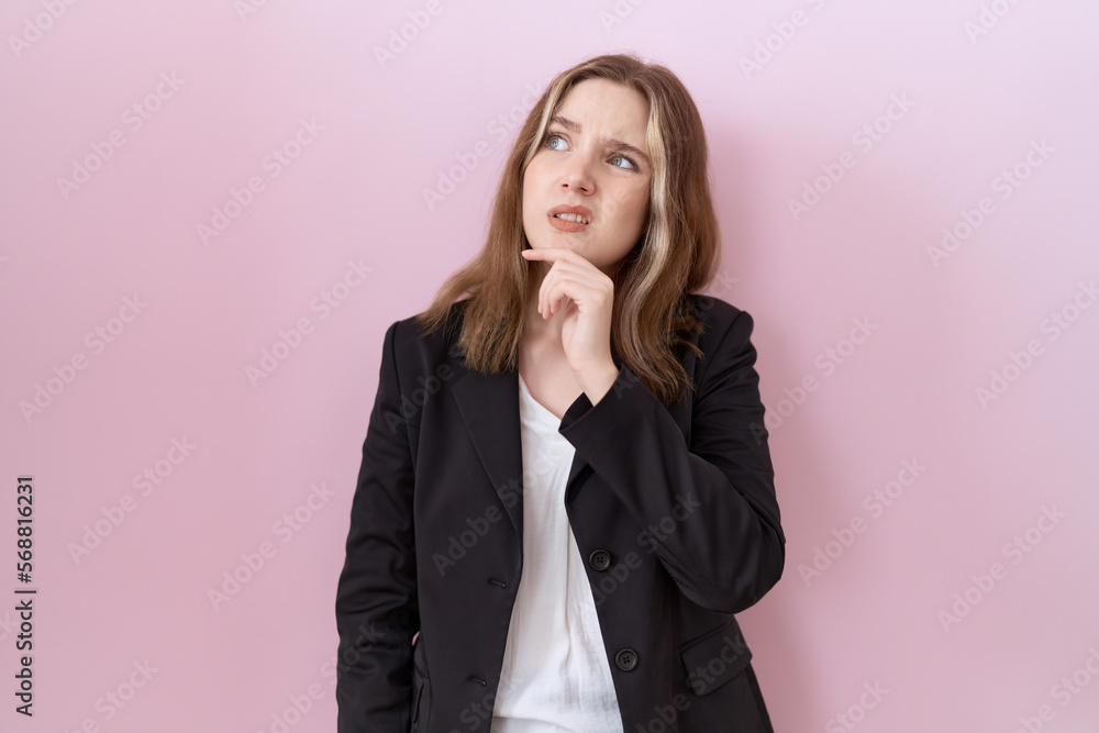 Young caucasian business woman wearing black jacket thinking worried about a question, concerned and nervous with hand on chin Young caucasian business woman wearing black jacket thinking worried about a question, concerned and nervous with hand on chin