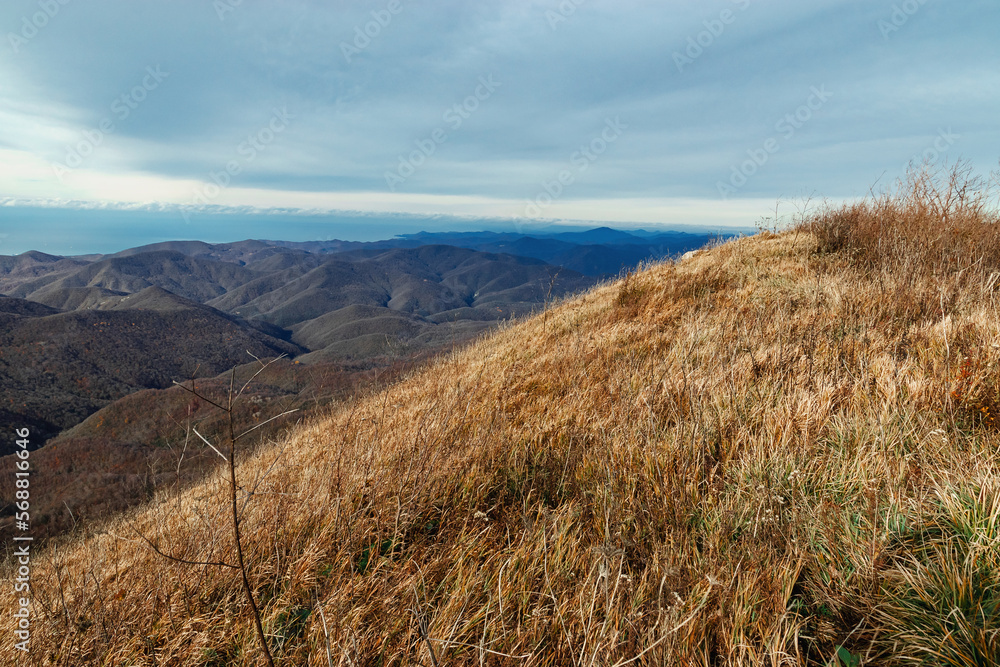 Fototapeta premium Mountain pass, mountain range. Beautiful mountain landscape. View from a great height in a picturesque place of the Caucasus. The mountain range of the Caucasus against the background of clouds. 
